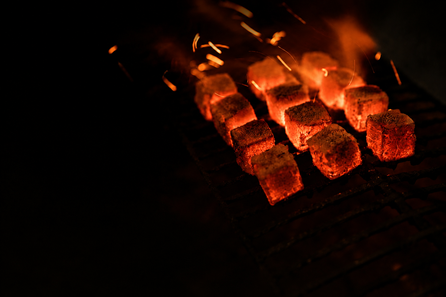 Indonesian coconut charcoal briquettes glowing during a burning evaluation